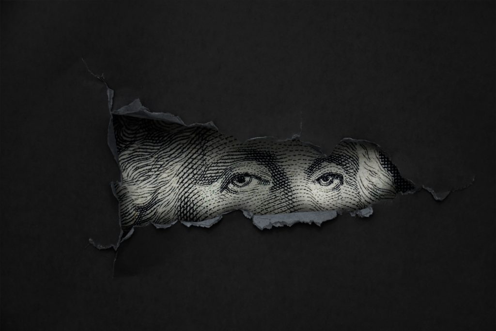black screen with hole where eyes of George Washington from US bill show through